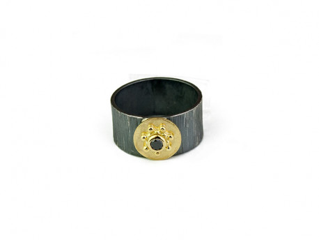 Anell d'argrent oxidat ratllat amb centre en or groc de 750 mm i Diamant negre talla brillant.