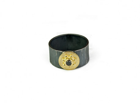 Striped oxidized silver ring with center in 750mm yellow gold and brilliant cut black diamond.