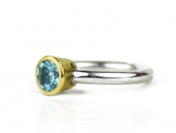 Anillo de plata y oro amarillo con topacio azul.